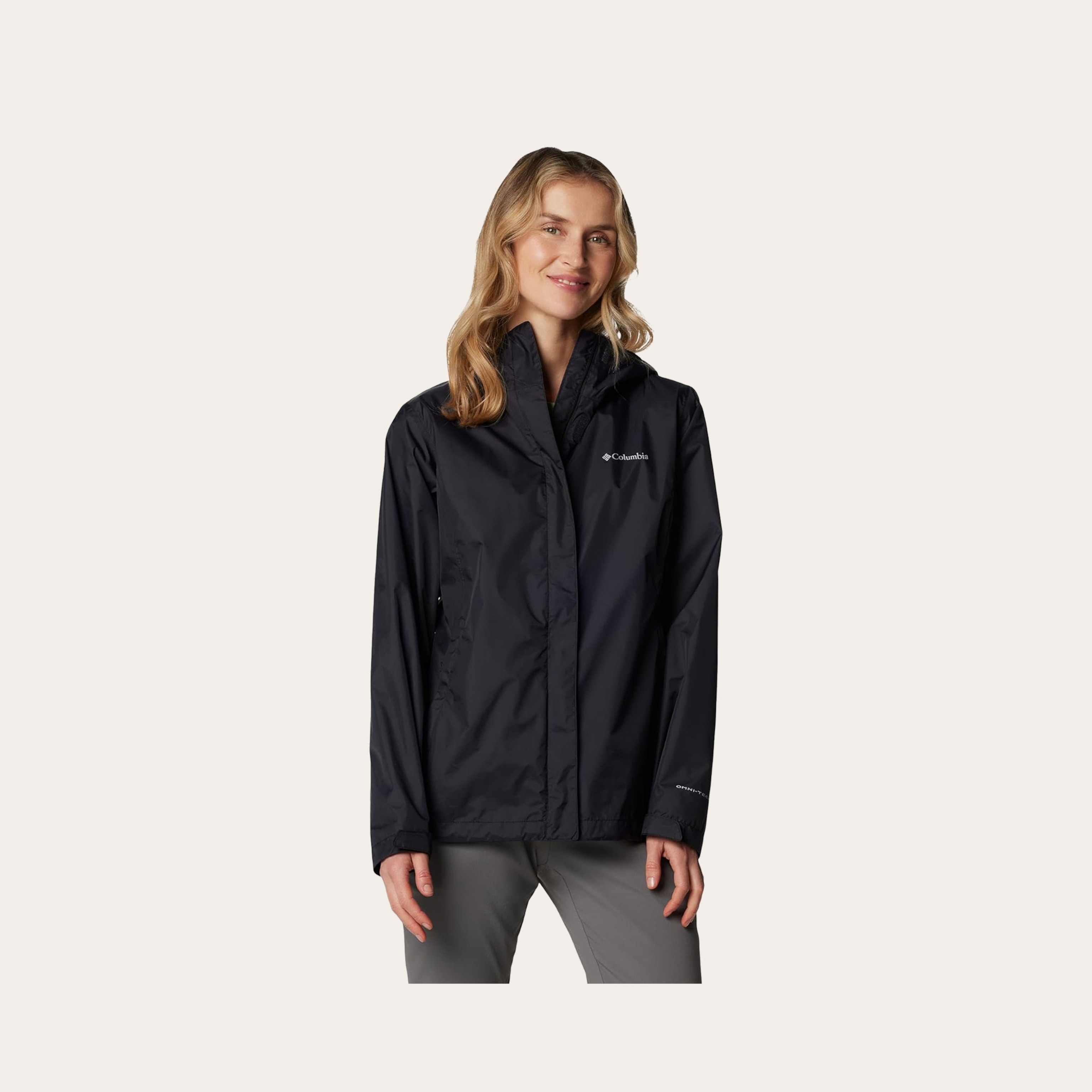 Woman wearing a black rain jacket placed in front of a tan background