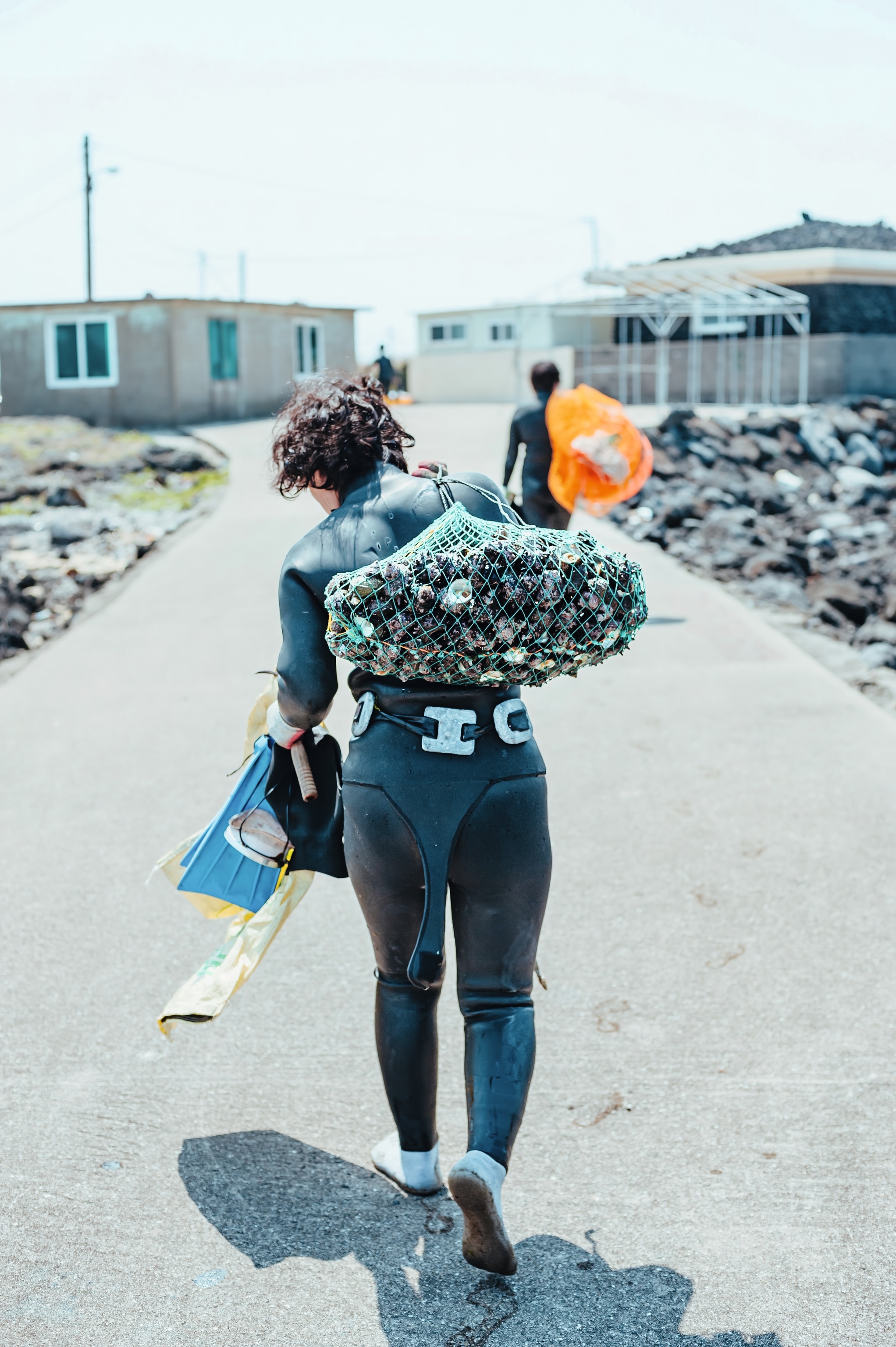 woman carrying seaurchins and shells