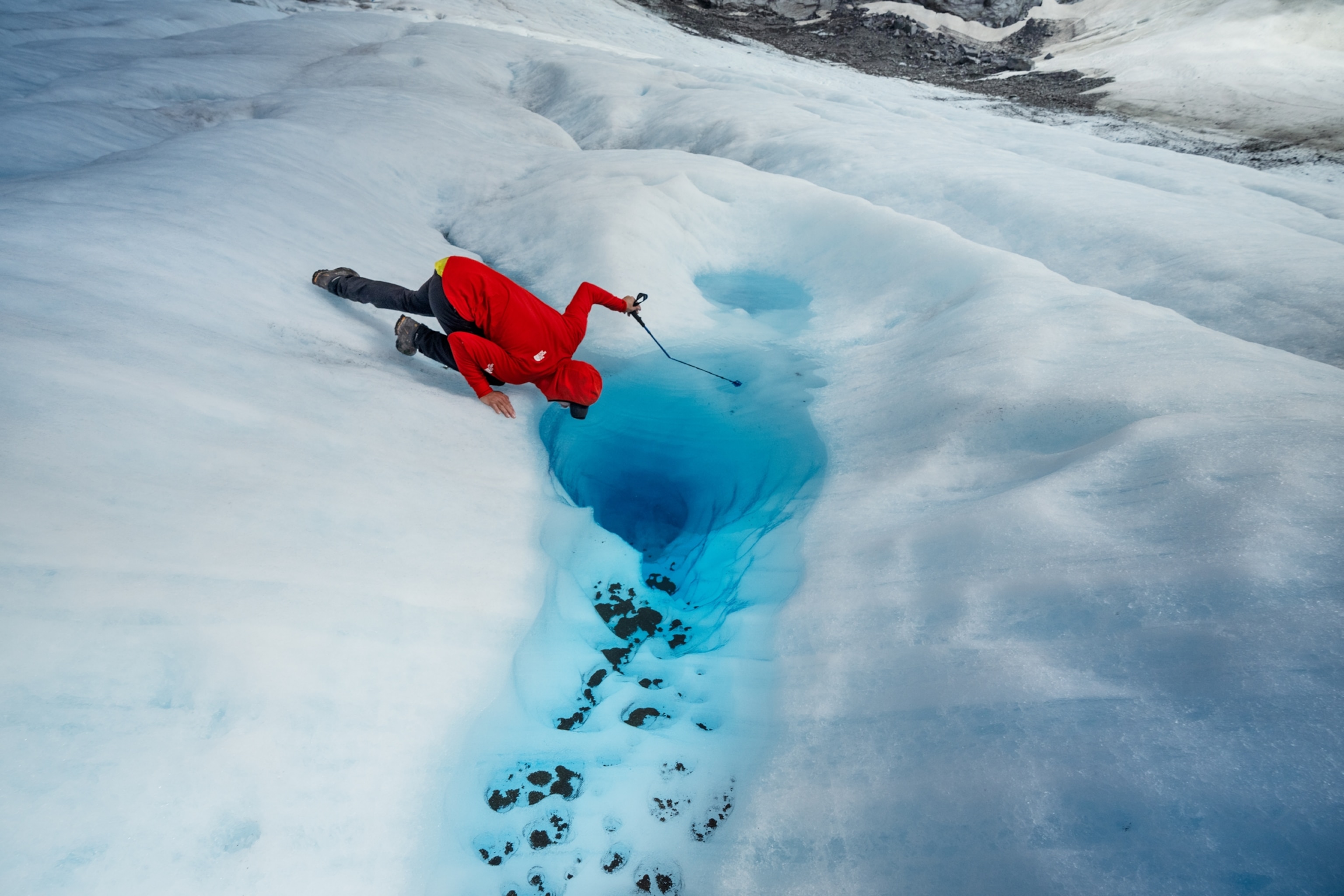 Honnold bends over to refresh with water from a small pool that has formed in a glacier