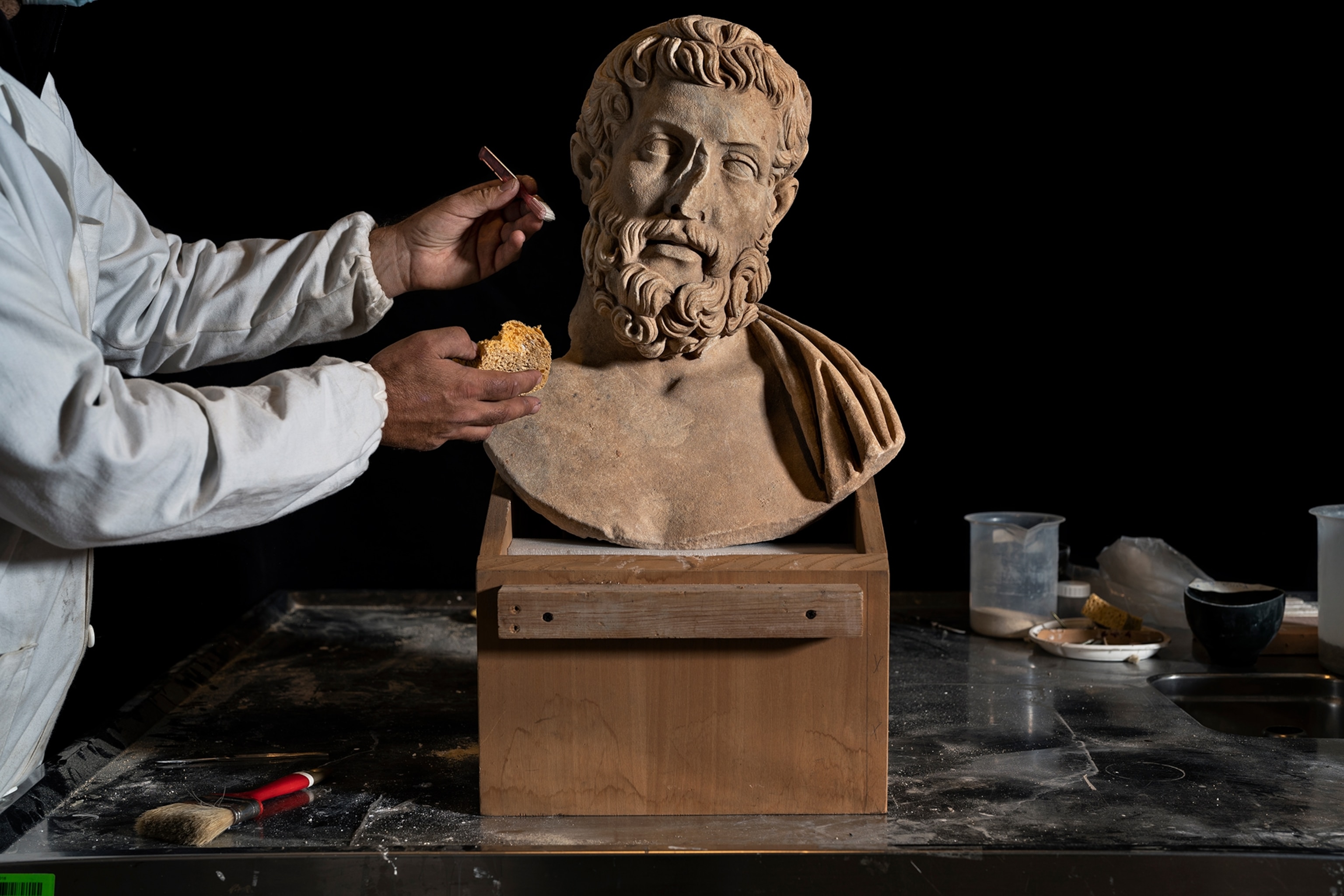 A bust is worked on by a researcher.